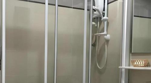 a shower with a glass door in a bathroom at Loong Fatt Hotel in Sungkai