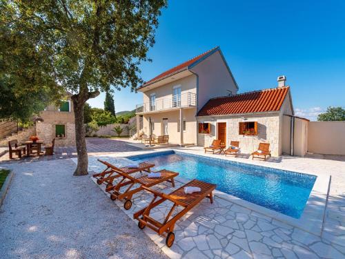 a villa with a swimming pool and a house at Dalmatia Pool Villa Retreat in Stankovci