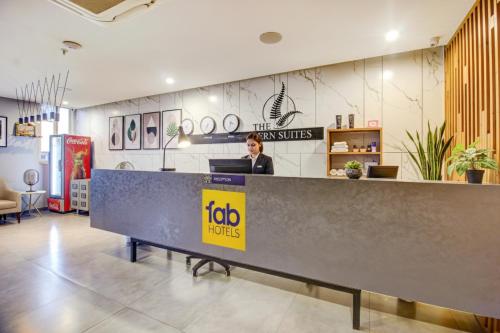 una mujer sentada en un mostrador de recepción en un restaurante en FabHotel SSR Fern Suites - 100M from GSM Mall Madeenaguda, en Lingampalli