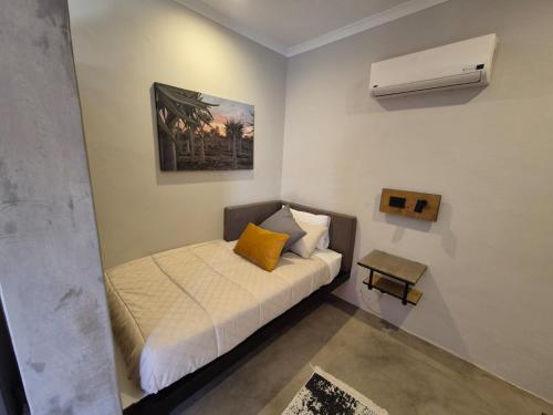 a small bedroom with a bed and a air conditioner at Die Stoor in Upington