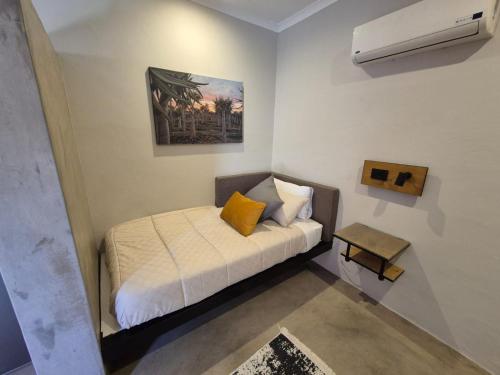 a small bedroom with a bed and a air conditioner at Die Stoor in Upington