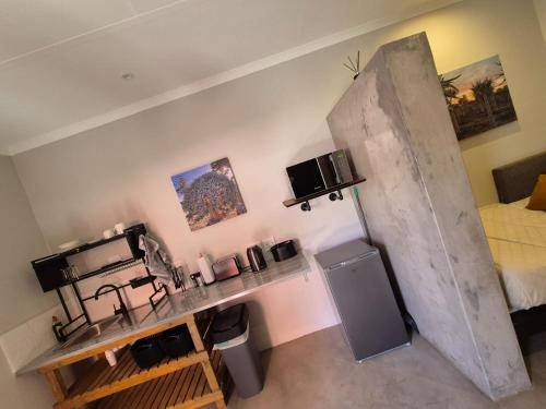 a kitchen with a counter and a room with a bed at Die Stoor in Upington