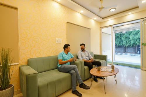 two men sitting on couches in a room at FabHotel Maark Inn - Bannerghatta Rd in Bengaluru
