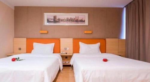 a hotel room with two beds with white sheets at 7 Days Premium Zhuhai Gongbei Light Railway Branch in Zhuhai