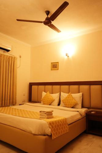 a bedroom with a bed with a ceiling fan at HOTEL SUN GREEN in Bhubaneshwar