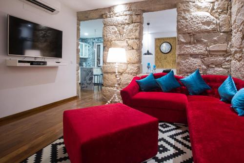 a living room with a red couch and a tv at GuestReady - Eiffel Waterfront apartments in Porto