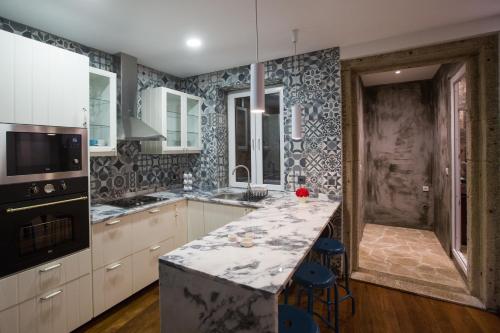 uma cozinha com armários brancos e uma bancada em mármore em Ribeira Flats MyGod no Porto