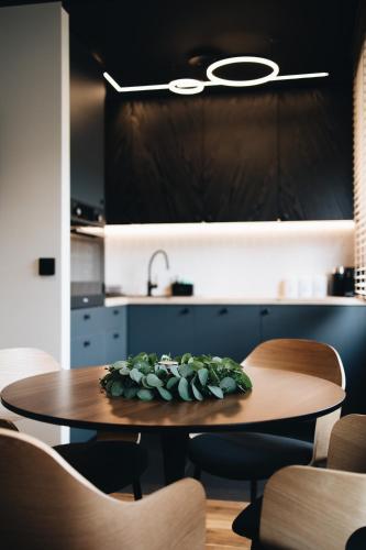 a table with a plant on it in a kitchen at Apartament WROTA DO PUSZCZY Z SAUNĄ in Hajnówka