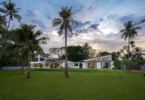 a house with palm trees in front of it at Kazuri in Alleppey