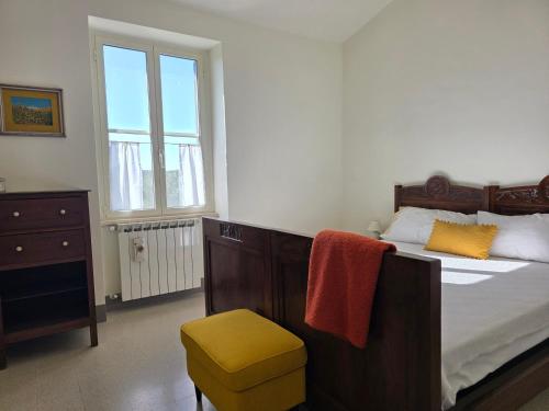 a bedroom with a bed and a chair and a window at Il casale di Sere Tarquinia in Tarquinia