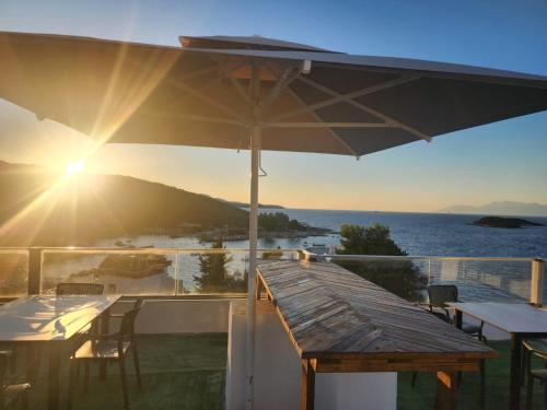 a deck with a table and an umbrella at Ventus Hotel in Ksamil