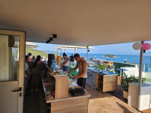 a group of people preparing food on a balcony at Ventus Hotel in Ksamil
