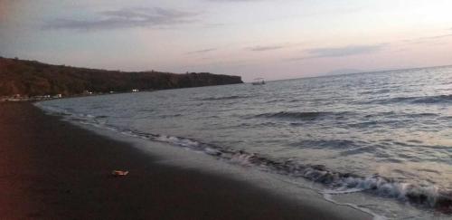a beach with a boat in the water at Kua's Pad Batangas Room in Lian