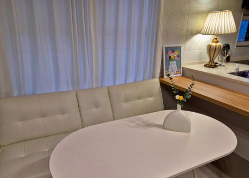 a white table and a couch in a room at Roome House in Seoul