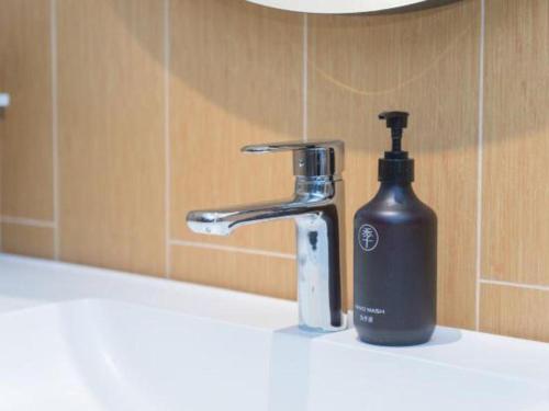 a bottle of soap next to a bathroom sink at 7 Days Inn Zhangjiakou Chongli Yuxing Road in Zhangjiakou