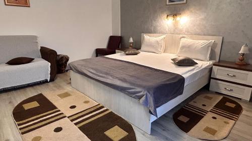 a bedroom with a large bed and a chair at Hotel Suprem in Băile Olăneşti