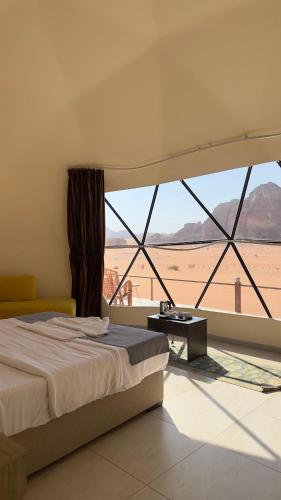 Schlafzimmer mit einem Bett und Blick auf die Wüste in der Unterkunft Martian landscape camp in Wadi Rum
