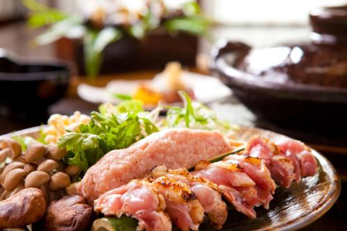 a plate of food with meat and vegetables on a table at Yufuin Souan Kosumosu in Yufuin