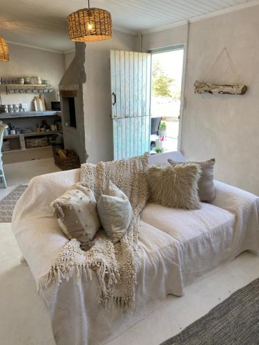 ein Wohnzimmer mit einer weißen Couch mit Kissen in der Unterkunft Soutbos Cottages in Laingsburg