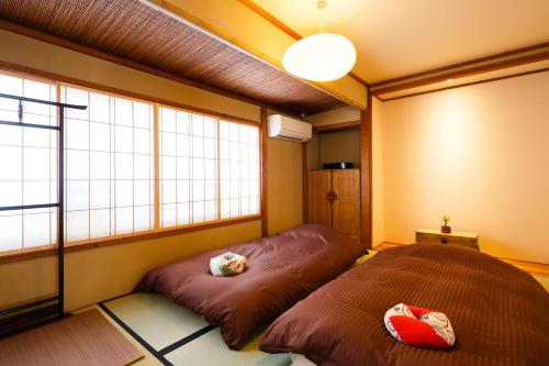 Kiyomizu Shukuba في كيوتو: غرفة نوم بسريرين ونافذة