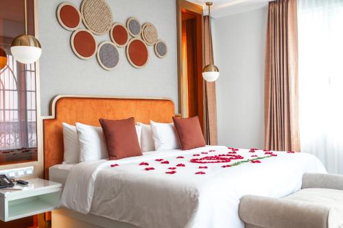 a bedroom with a large white bed with red flowers on it at La Seine Hotel in Vientiane