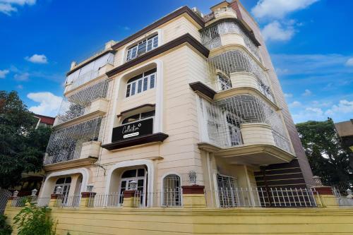 a tall white building with a balcony at Collection O Jyotirindra Nandi Metro Station Kolkata Formerly Hotel Manurama in Jādabpur