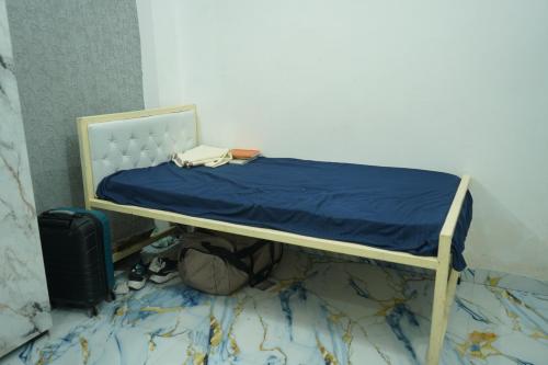 a bed with a blue blanket on top of it at Lavish PG in Lucknow