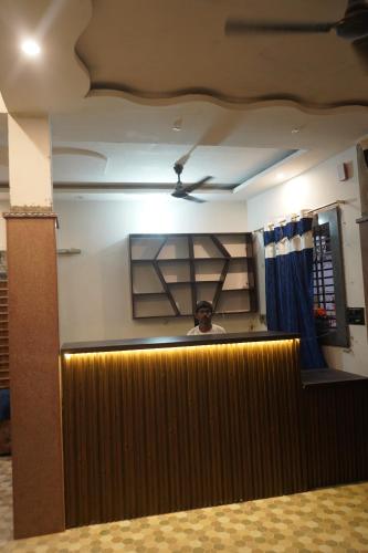 a man is standing behind a counter in a room at Lavish PG in Lucknow