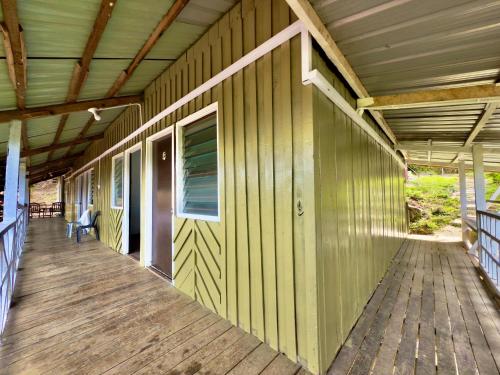 an empty porch of a house with a wooden deck at Rustic Bed & Breakfast in Ranau