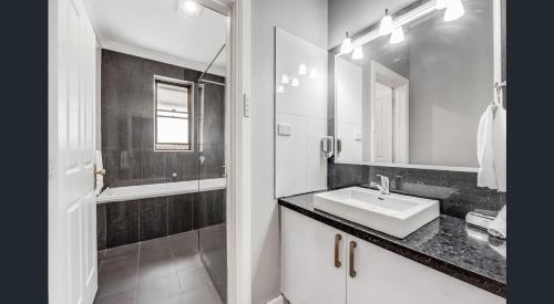a bathroom with a sink and a mirror and a shower at Cosy Lodge Mount Gambier close to shopping, eating in Mount Gambier