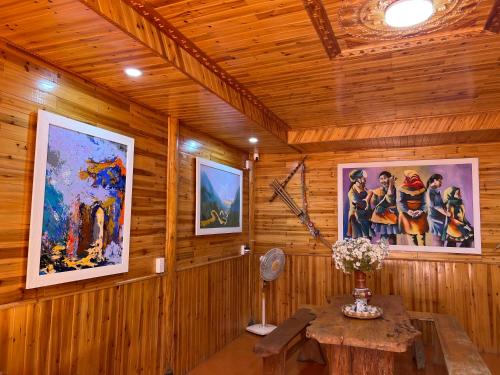 a room with a wooden wall with paintings on it at Homestay Quản Thanh in Loung Co