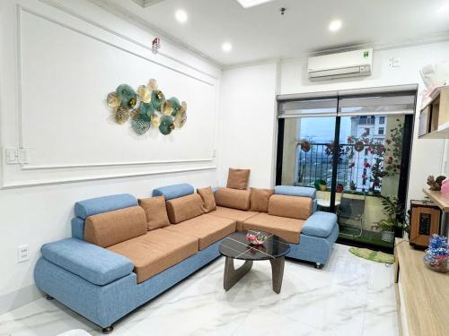 a living room with a couch and two blue chairs at Happiest Homestay 1 - Manor Crown Hue in Hue