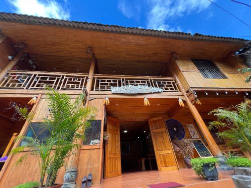 a wooden building with a balcony on top of it at Homestay Quản Thanh in Loung Co