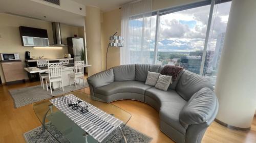 un salon avec un canapé gris et une cuisine dans l'établissement Luxury Nightlights NELLI Apartment, à Tallinn