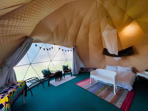 a room with a tent with a bed and a table at Yellow House in Hengchun