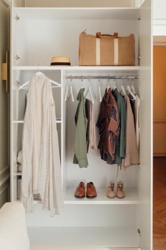 a white closet with clothes and shoes at Nosteo in Athens
