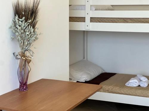 a vase of flowers sitting on a table next to a bunk bed at Brebei Niedda Hostel in Gonnesa