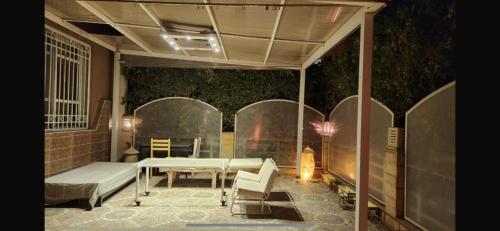 een patio met een bank en een tafel en stoelen bij Maison Verde Madinaty in Banī Ghālib