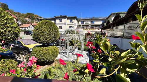 a garden with a bird cage in the middle of flowers at Hotel Suprem in Băile Olăneşti