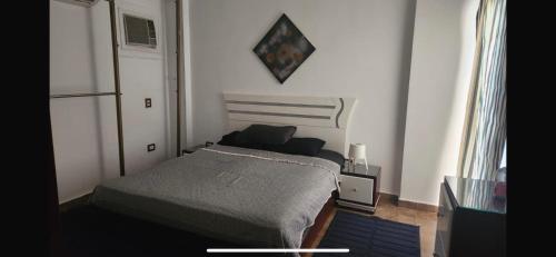 een kleine slaapkamer met een bed en een raam bij Maison Verde Madinaty in Banī Ghālib