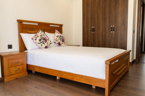 a bedroom with a large bed with a wooden headboard at Villa 4-Bedroom with Private Pool & Rooftop Sea View in Tamaris in Casablanca