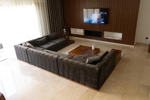 a living room with a couch and a tv at Villa 4-Bedroom with Private Pool & Rooftop Sea View in Tamaris in Casablanca