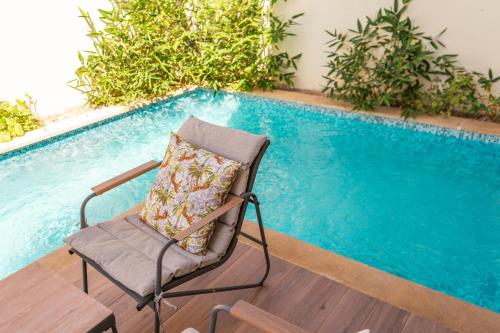 a chair sitting next to a swimming pool at Villa 4-Bedroom with Private Pool & Rooftop Sea View in Tamaris in Casablanca