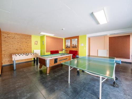 a room with two ping pong tables in it at Moderscheid Cottage with Spa in Amblève