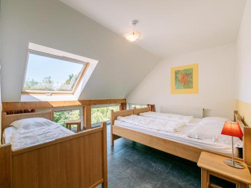 a bedroom with two beds and a window at Moderscheid Cottage with Spa in Amblève