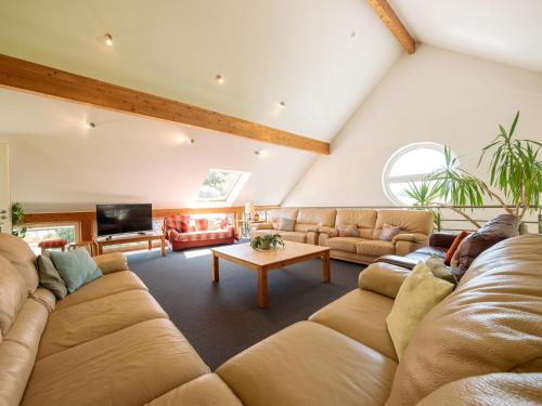 a large living room with a couch and a table at Moderscheid Cottage with Spa in Amblève