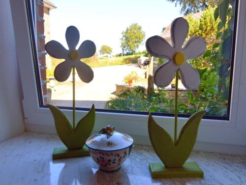 two fake flowers in front of a window at Moderscheid Cottage with Spa in Amblève
