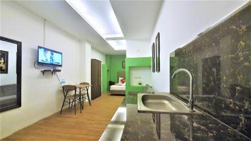 a kitchen with a sink and a tv on the wall at Spiral Suites Hotel in Manila