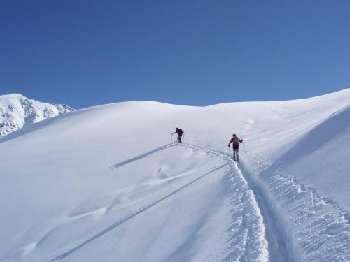 two people skiing down a snow covered mountain at Cozy apartment in Außervillgraten in Außervillgraten