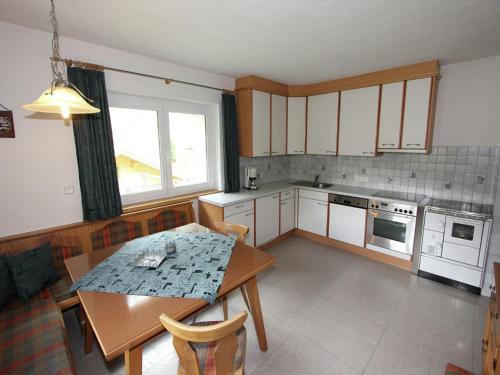 a kitchen with a table and a table and chairs at Cozy apartment in Außervillgraten in Außervillgraten